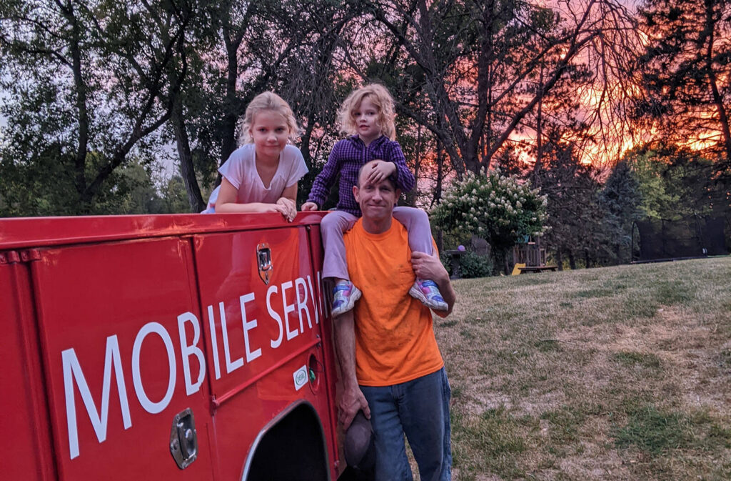 Adam Fournier with his daughters on his mobile service truck